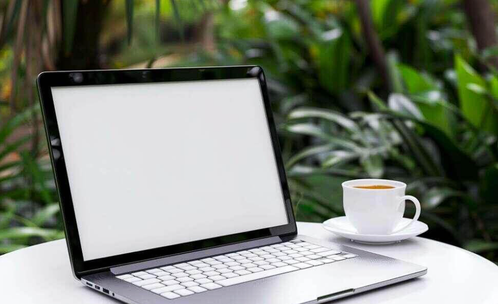 open laptop computer and coffee on white table