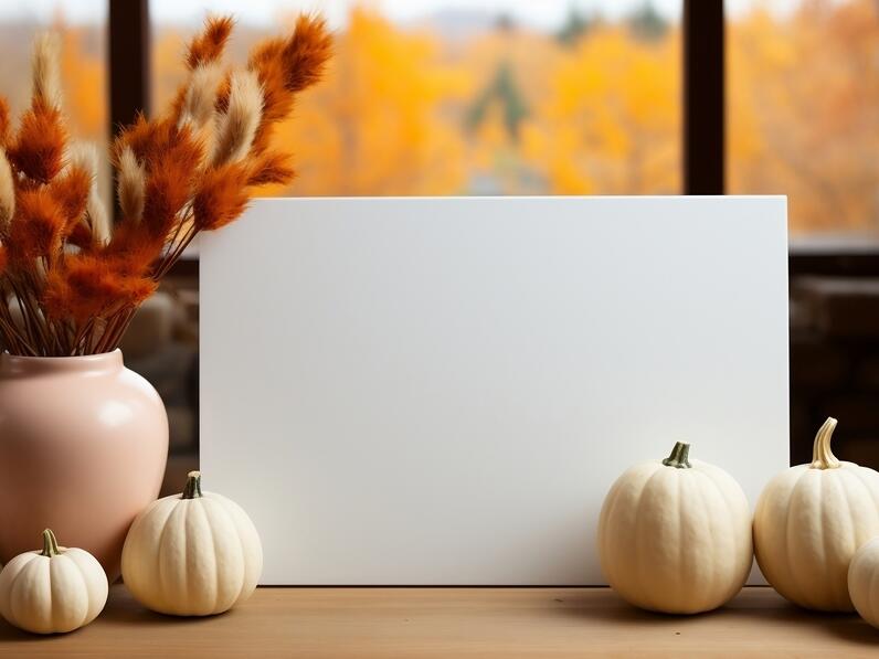 Poster Mockups autumn themed table setting with white board, pumpkins, and flowers